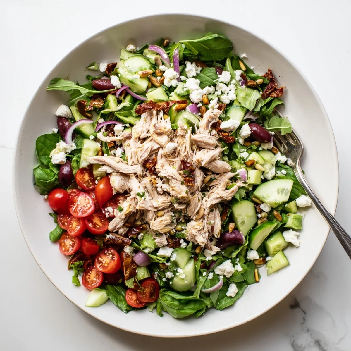 Mediterranean-style sun-dried tomato chicken salad tossed with fresh greens, cherry tomatoes, and tangy dressing