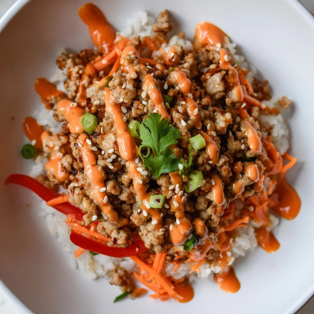 Hearty ground turkey rice bowls topped with vibrant crisp veggies and creamy spicy Bang Bang sauce