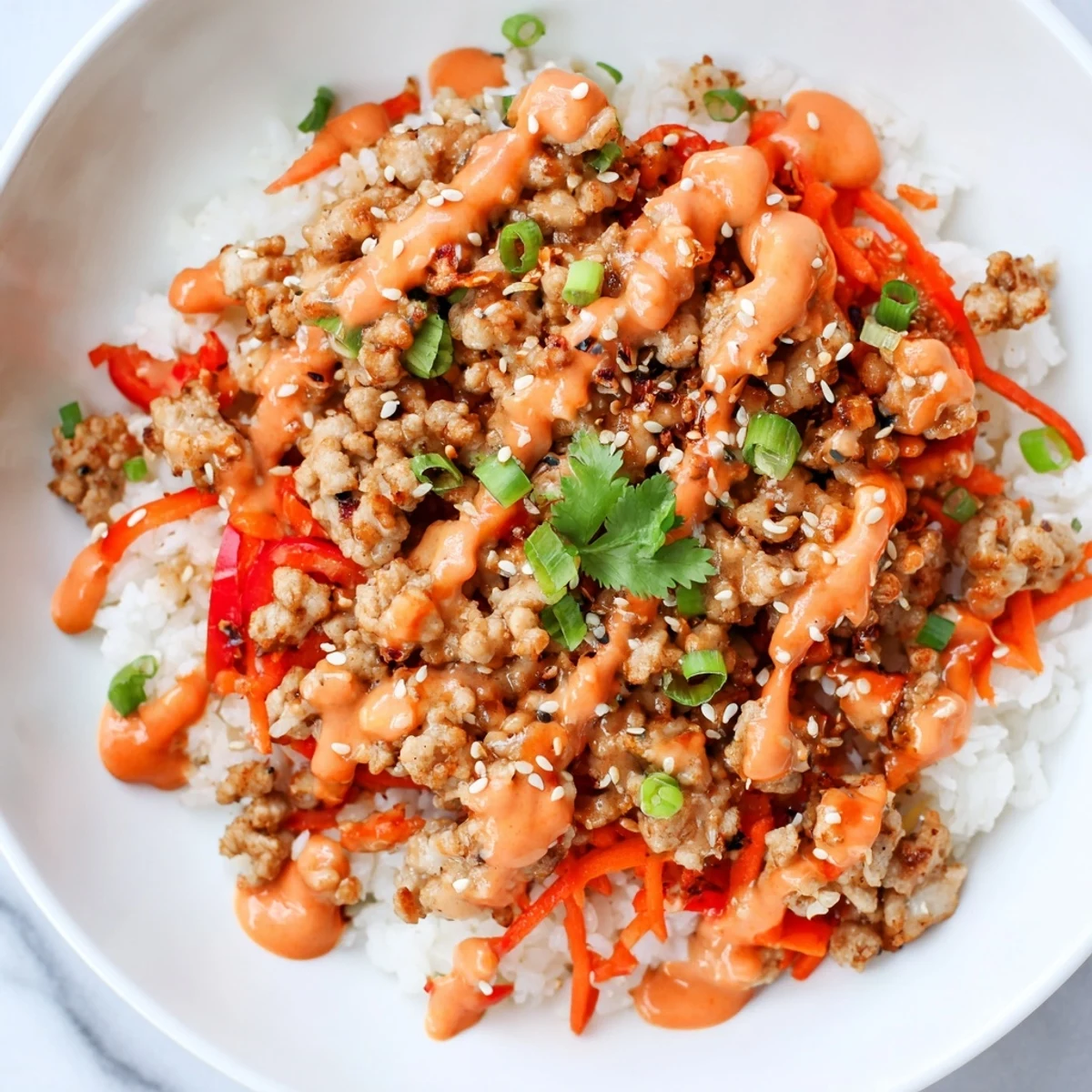 Steaming jasmine rice loaded with seasoned ground turkey and drizzled with zesty Bang Bang sauce